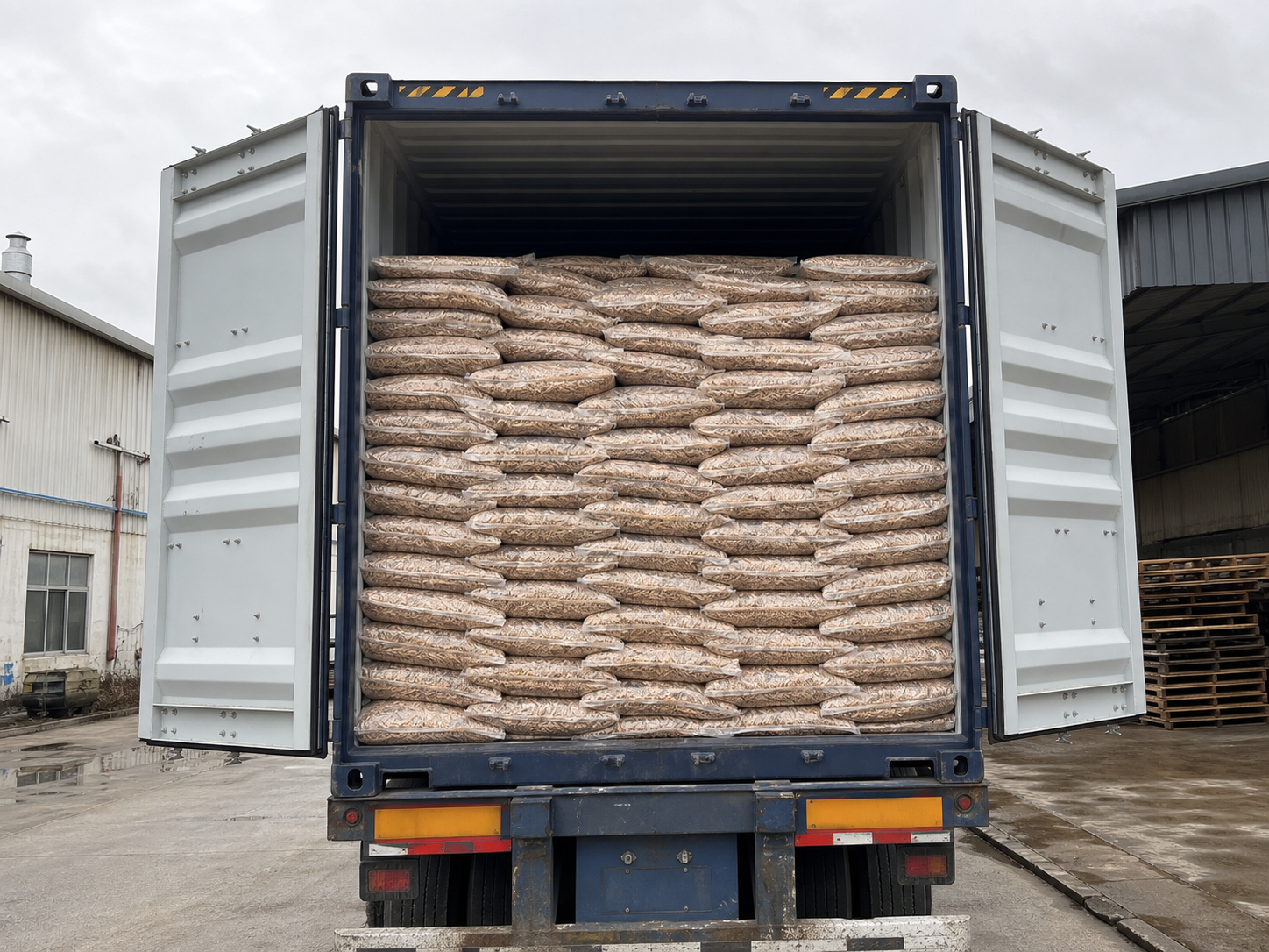 A customer shipment container densely loaded with bagged wooden products for distributors and importers